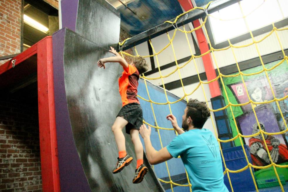 a person helping a child climb a wall