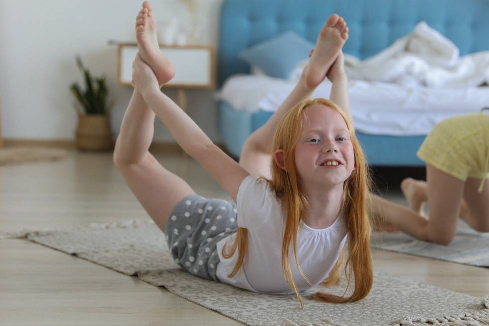 a child doing yoga on the floor