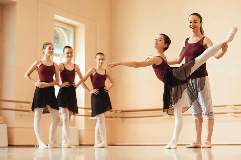 a group of women in ballet clothes and dancing