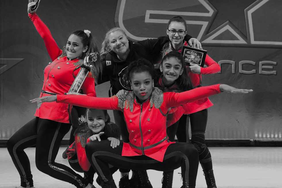 A group of women dancers in red outfits posing for the camera